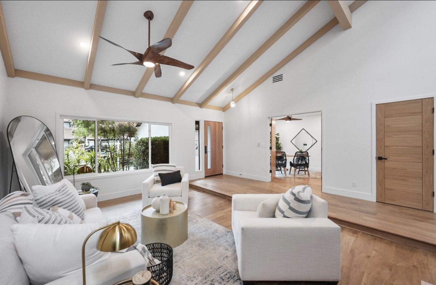 Managed home's bright living room with exposed wood beams and large windows